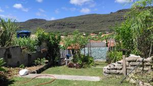 a garden with a hose in front of a body of water at Hostel Mucugê in Mucugê
