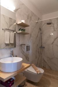 ein Bad mit einem Waschbecken, einem WC und einer Dusche in der Unterkunft Anastasia's Suites Arcadia in Vitina