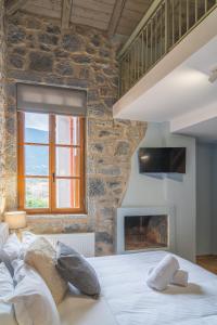 ein Schlafzimmer mit einem großen Bett und einem Kamin in der Unterkunft Anastasia's Suites Arcadia in Vitina
