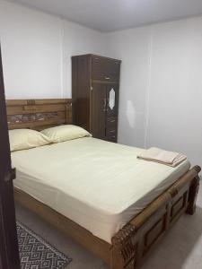 - une chambre avec un grand lit et une tête de lit en bois dans l'établissement Apartamento Vacacional Riohacha, à Ríohacha