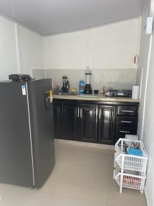 - une cuisine avec des armoires noires et un réfrigérateur dans l'établissement Apartamento Vacacional Riohacha, à Ríohacha