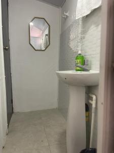 y baño con lavabo blanco y espejo. en Apartamento Vacacional Riohacha, en Ríohacha