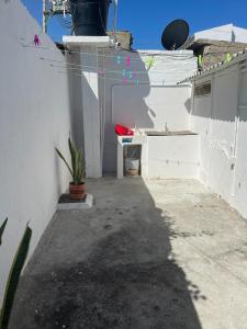 a patio with a white wall and a table and a plant at Apartamento Vacacional Riohacha in Ríohacha