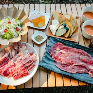 a table topped with different types of meat and food at 煙神キャンプヴィレッジ in Toyooka