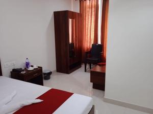 a bedroom with a bed and a desk and a chair at HOTEL HAREN GRAND in Guwahati