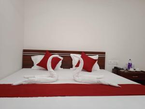 a bed with red and white pillows on it at HOTEL HAREN GRAND in Guwahati