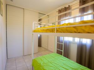 a bedroom with two bunk beds and a green bed at Maison à Salignac-Eyvigues avec terrasse, Wifi et parking - FR-1-616-116 in Salignac Eyvigues