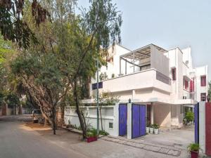 a white house with blue doors on a street at Haveli Hauz Khas in New Delhi