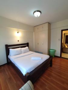 - une chambre avec un grand lit blanc dans l'établissement Lux Suites Marcus Garden Apartments kilimani, à Nairobi