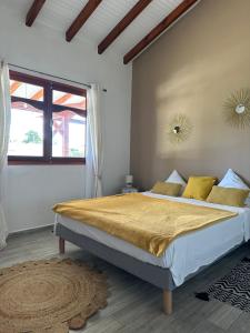 Capesterre的住宿－Villa Belle Ile en Mer，白色卧室配有一张带黄色床单的大床