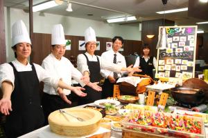 a group of chefs standing in a kitchen preparing food at Hotel Naturwald Furano in Furano
