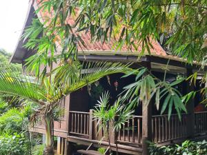 uma casa com varanda no meio das árvores em Thai Heritage Koh Mak em Ko Mak
