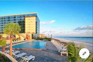 een hotel met een zwembad naast het strand bij oceanside inn in Daytona Beach