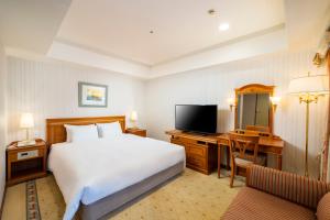 a bedroom with a bed and a desk and a television at KOKO Hotel Nagoya Sakae in Nagoya