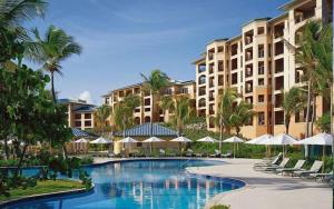 ein Resort mit einem Pool mit Stühlen und Sonnenschirmen in der Unterkunft Ritz Carlton in Nazareth