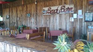 SUMMER HOMES BEACH RESORT في بورت بارتون: مطعم بطاولات وكراسي وعلامة مكتوب عليها بار خلفي