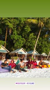 a group of people sitting on the beach at Evelin cottage in Ohoililir