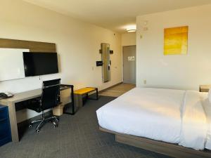 a hotel room with a bed and a desk and a computer at Comfort Inn & Suites Wylie in Wylie