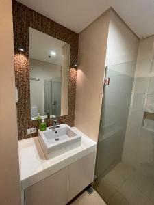 a bathroom with a white sink and a shower at Luxurious Family Room Pico de Loro in Nasugbu