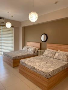 a bedroom with two beds and a mirror and chandeliers at Luxurious Family Room Pico de Loro in Nasugbu