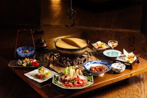 uma mesa com pratos de comida numa mesa em Hotel Yamabuki em Komagane