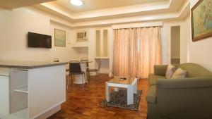 - un salon avec un canapé et une table dans l'établissement Sunnette Tower Makati, à Manille