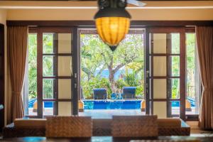 a dining room with a view of a tree at Amertha Bali Villas in Pemuteran