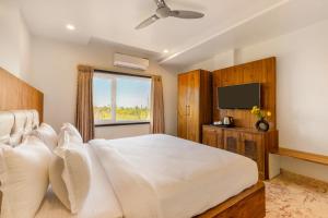 a bedroom with a large bed and a television at Seasons - A Boutique Hotel-Nearby Biological Park in Udaipur