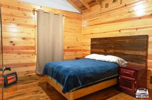 una camera con letto e parete in legno di AMANECER EN MEXIQUILLO - Cabaña encantadora y enorme a La Ciudad