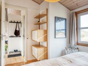 1 dormitorio con cama y estanterías de madera en Holiday home Pandrup XXX, en Pandrup