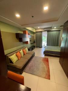 ein Wohnzimmer mit einem Sofa und einem Bett in der Unterkunft Luxurious Family Room Pico de Loro in Nasugbu