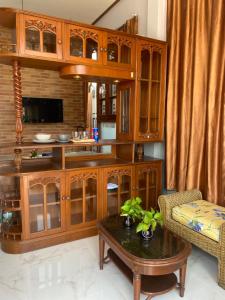 a living room with wooden cabinets and a coffee table at Kp. เพลส หลวงแพ่ง (Kp. Place Luang Phaeng) in Ban Bang Bo
