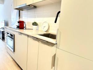 a white kitchen with a sink and a refrigerator at 1406 Sainte Elisabeth in Montreal