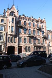 un gran edificio de ladrillo con coches estacionados frente a él en Shelfort Hotel, en San Petersburgo