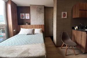 um quarto com uma cama e uma cadeira em 701 Loft amazing view em Medellín