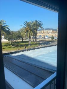 a view from a window of a beach with palm trees at Loft vistes al mar 50 mts to Palamós Beach in Palamós