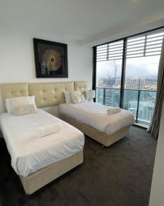 黄金海岸4 Bedroom Huge Sub Penthouse Oracle Level 31 Magnif VIEWS 260m2 Family Skyhome Sleeps 8 Adults and 2 Children, Sofa Bed Portacot, High Chair Central to Everything Resort Skyhome 5 STAR Luxury的一间有大窗户的房间里有两张床 更多37张照片