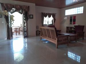 a living room with two benches and a table at Harmony House Stay in Padangbai