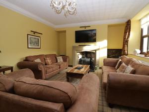 sala de estar con muebles marrones y chimenea en Groffa Crag Farmhouse en Lowick Green