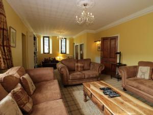 a living room with couches and a coffee table at Groffa Crag Farmhouse in Lowick Green