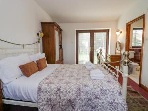 1 dormitorio con 1 cama grande y baño en Groffa Crag Farmhouse en Lowick Green