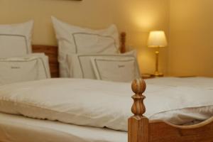 - une chambre avec 2 lits avec des draps blancs et une lampe dans l'établissement Appartement in Spiegelau mit Terrasse und Garten, à Spiegelau