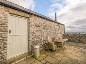 un edificio de ladrillo con una puerta de garaje blanca y una mesa en Five Wells Barn, en Flagg