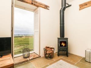 sala de estar con chimenea y ventana en Five Wells Barn, en Flagg