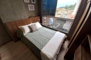 1 dormitorio con cama y ventana grande en 702 Belen, Loft amazing view, en Medellín