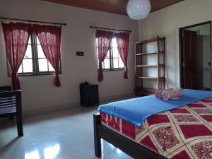 a bedroom with a bed in a room with windows at Harmony House Stay in Padangbai