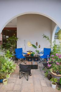 a patio with chairs and a table and some plants at Crossover Hub Family Balcony Room in George Town