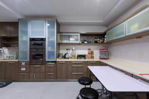 a kitchen with wooden cabinets and a white counter top at Crossover Hub Family Balcony Room in George Town