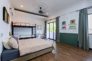 a bedroom with a bed and a large window at Crossover Hub Family Balcony Room in George Town
