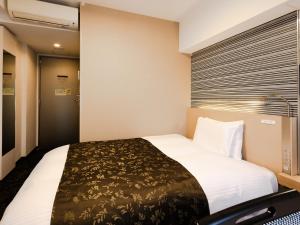 a bedroom with a bed and a window at APA Hotel Nagoya Fushimi Ekikita in Nagoya